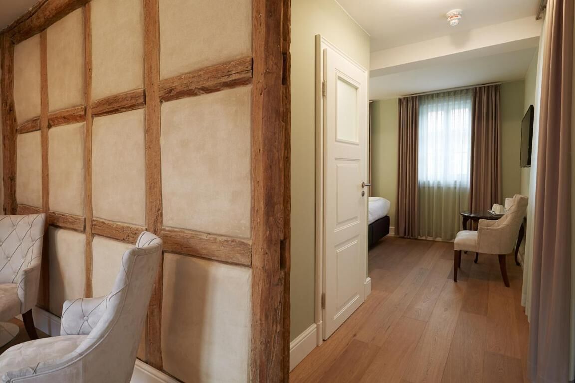A hotel room with a wooden panel wall, a bed, a desk, and a chair.