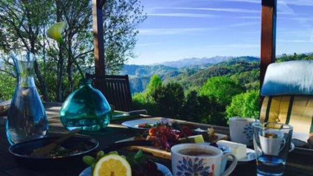 A table set outdoors with a view of a mountainous landscape. - "Casa Sira", a privilege for the senses (Villaviciosa)