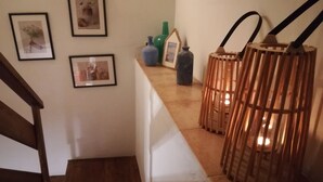 A staircase with wooden steps leading to a landing where framed pictures are hung on the wall. - "Casa Sira", a privilege for the senses (Villaviciosa)