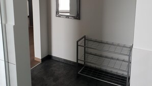 Ein Flur mit einem Spiegel, einem Metallgestell und einem Schild mit der Aufschrift 'Welcome'.