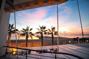 Eine Terrasse mit Blick auf den Strand und den Sonnenuntergang.