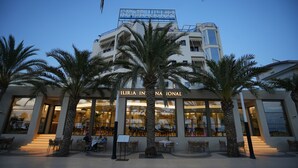 A hotel with a modern facade, large windows, and outdoor seating. - Hotel Iliria Internacional (Durrës)
