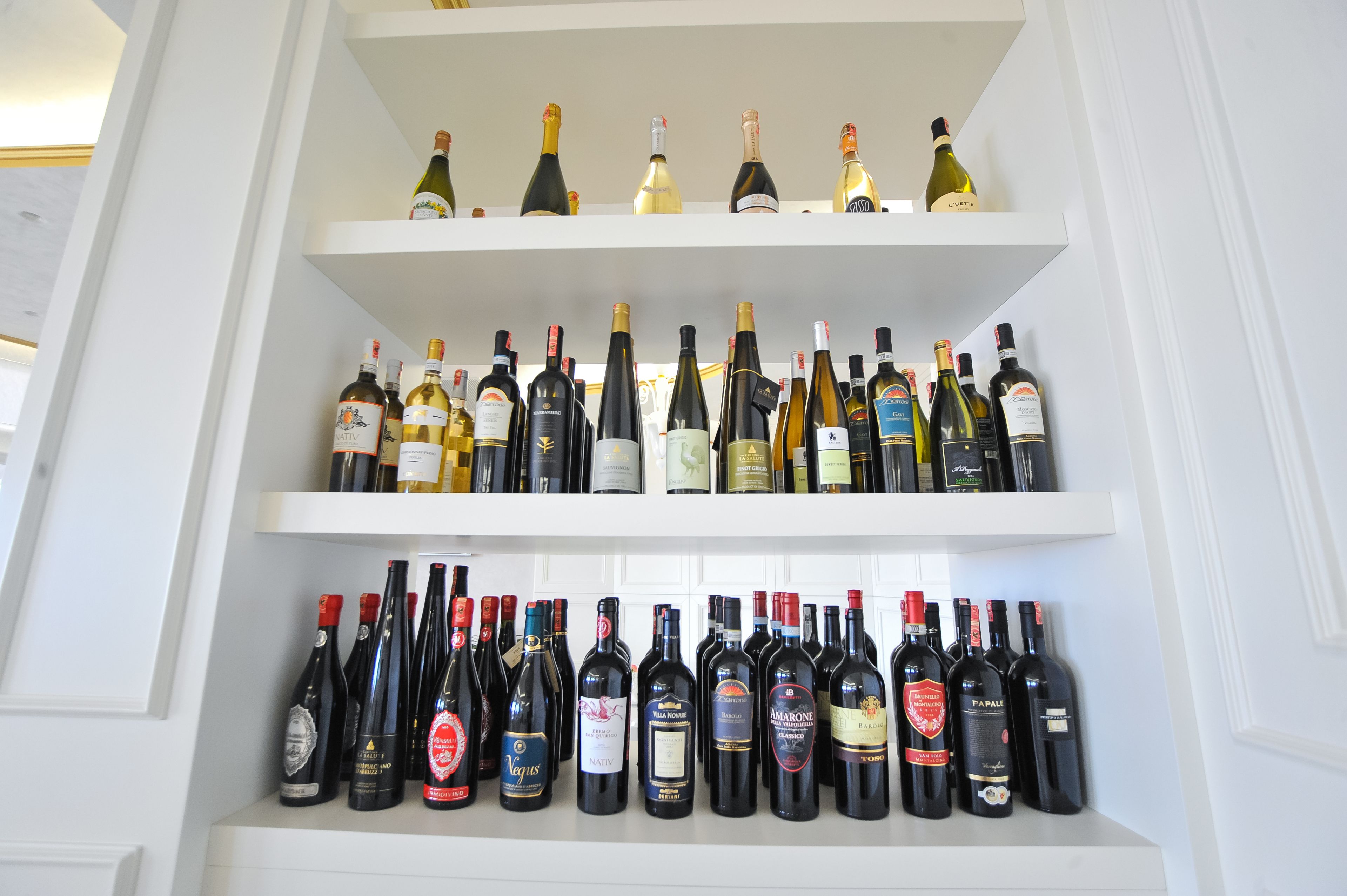 A wine rack with multiple shelves holding various wine bottles.