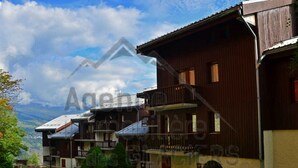 Il s’agit d’un bâtiment de style chalet traditionnel, doté d’une façade en bois, d’un balcon et d’une petite structure attenante.