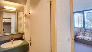 Une salle de bain équipée d’un lavabo, d’un miroir et d’un porte-serviettes.