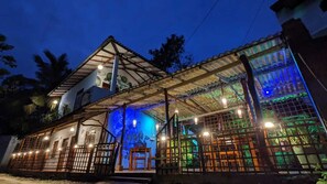 Vista frontal de la propiedad por la tarde o noche