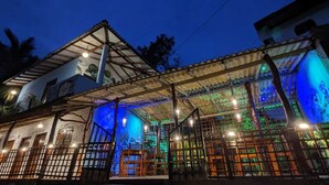 Un edificio con un patio cubierto, un mural en la pared y un letrero que dice "SADIK".