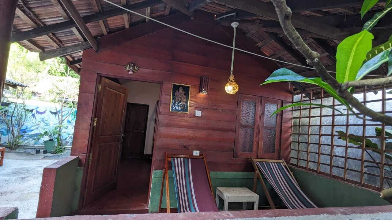 A wooden structure with a porch, a hanging light fixture, and a framed picture on the wall.