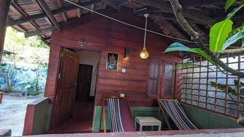 A wooden structure with a porch, a hanging light fixture, and a framed picture on the wall.