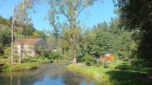 Un entorno tranquilo junto al río con una casa y un granero.