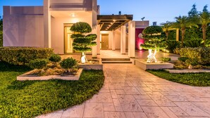 Un bâtiment moderne doté d’un porche, de jardins bien entretenus et d’un chemin pavé menant à l’entrée.