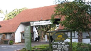 Un panneau indiquant le parc national de Nairobi, avec des indications pour vous rendre à la boutique de souvenirs, au service de gestion des cartes à puce, au point de distribution et au point de vente.