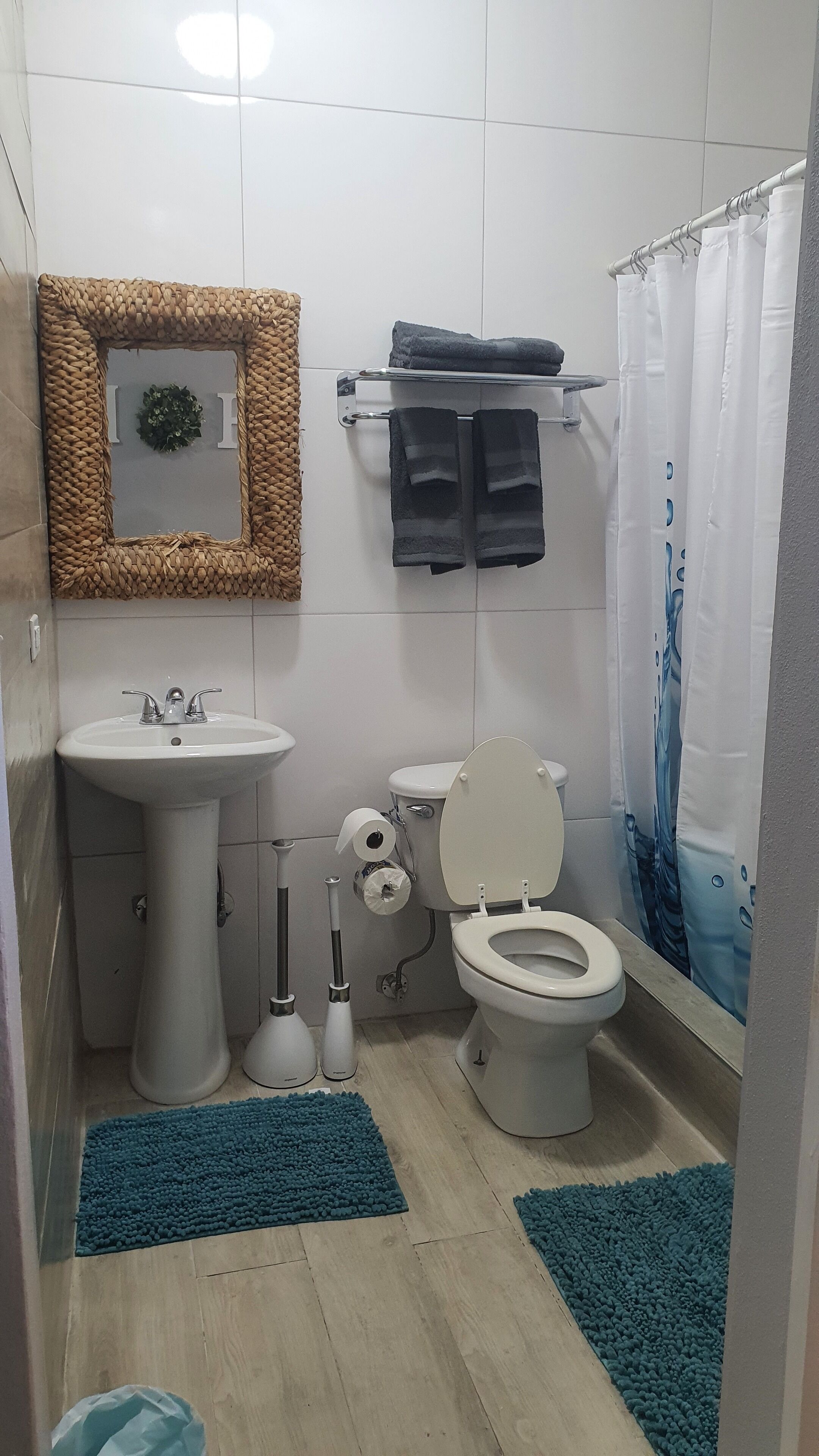 Kylpyhuone, jossa on pesuallas, wc ja suihkuverho.
