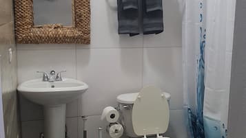 Une salle de bain équipée d’un lavabo, de toilettes et d’un rideau de douche.