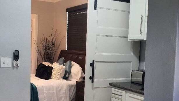 A compact room with a bed, a desk, and a cabinet. - Kozy Bahamas Getaway (Nassau)
