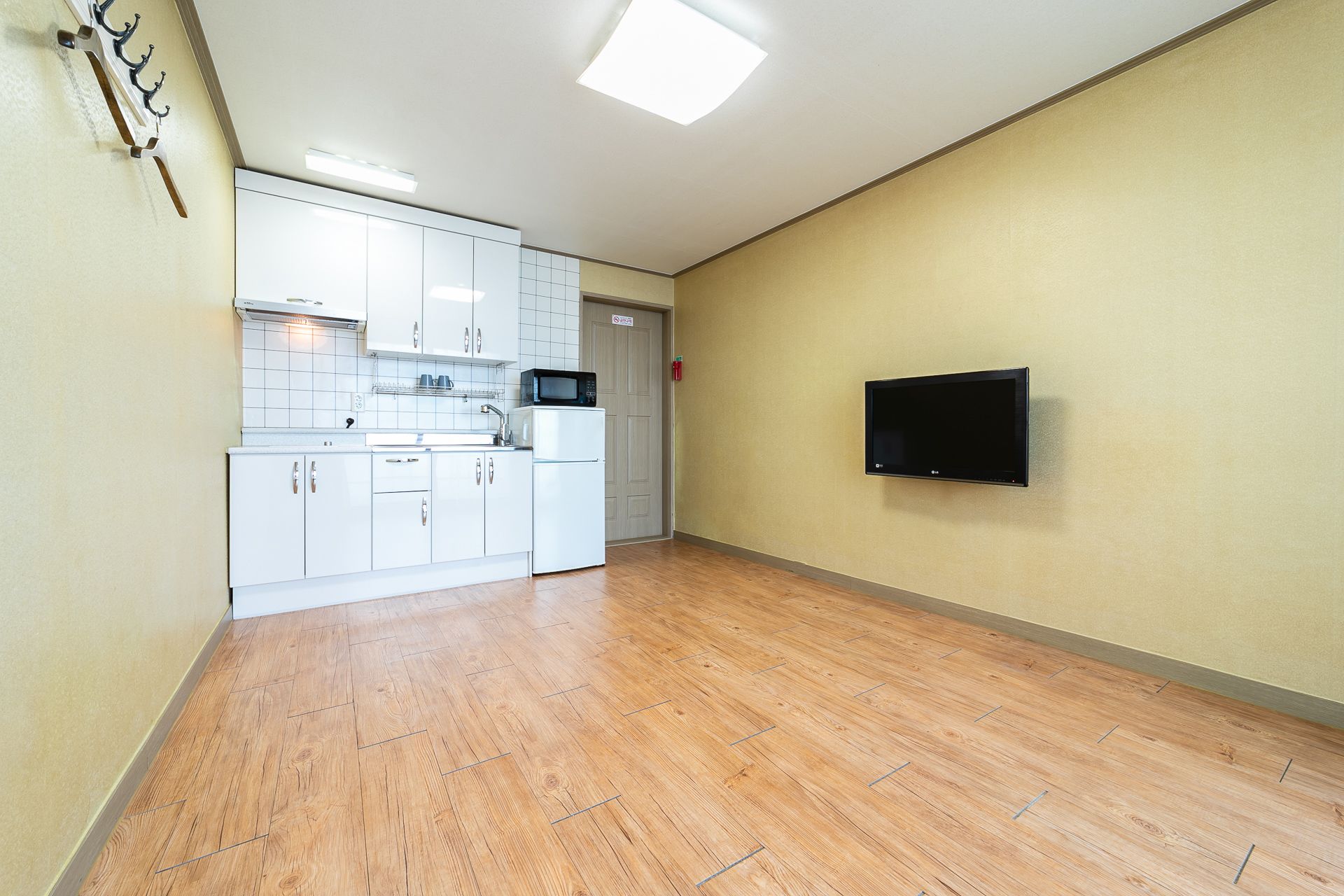 A modern kitchen with white cabinets, a microwave, and a built-in oven.
