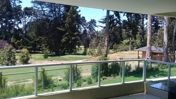 Varanda com vista para uma paisagem verde e árvores.