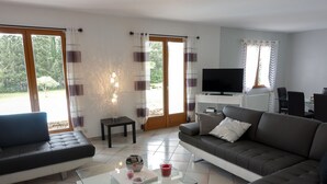 A modern living room with a sofa, a coffee table, and a TV. - Villa Queen-South IT (Ventenac-Cabardès)