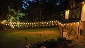 A stone building with a patio area, string lights, and outdoor seating. - Makanda Inn (Makanda)