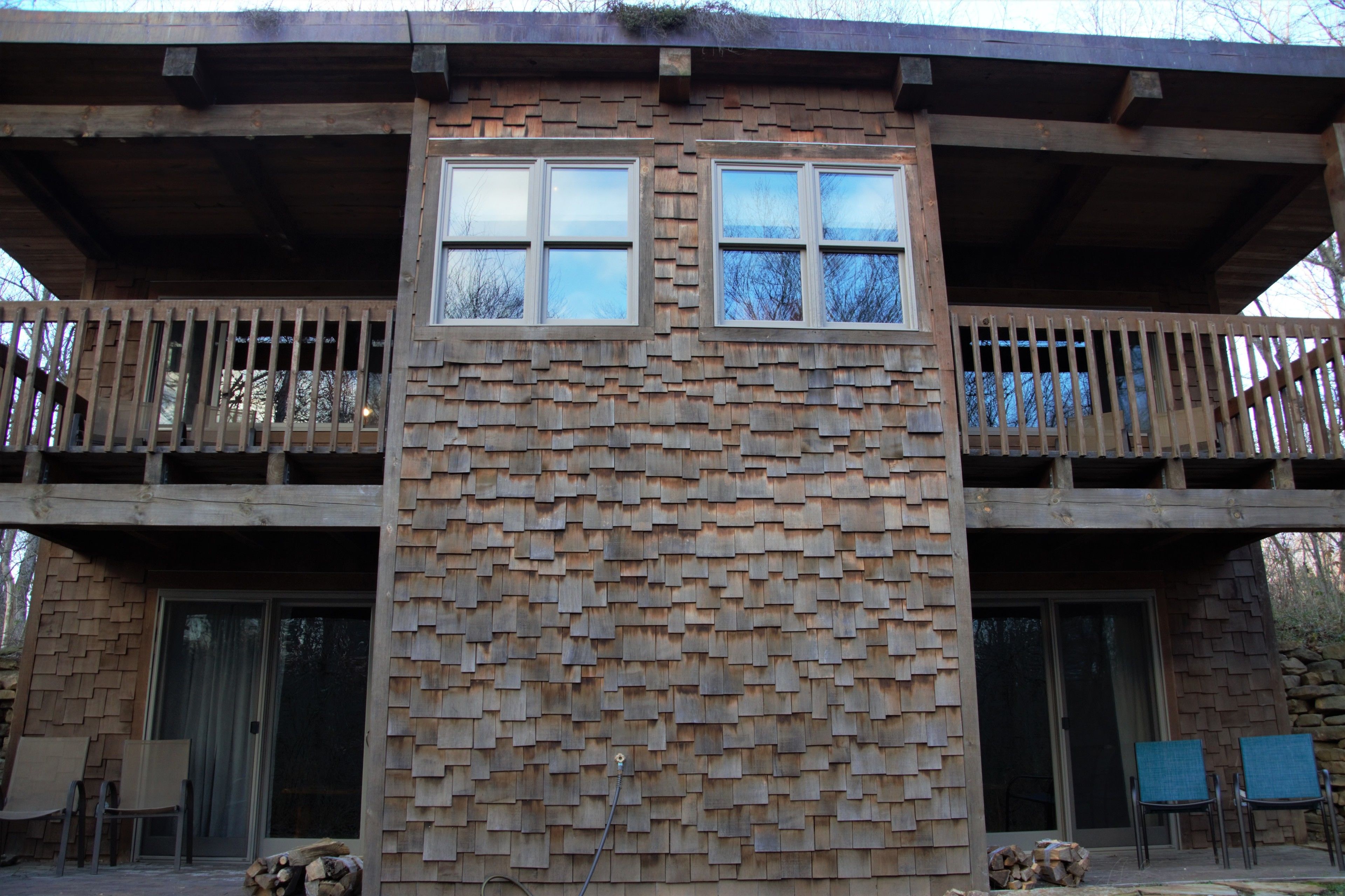 Un bâtiment à deux étages doté d’une façade en bois et de balcons.
