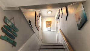 A staircase with a handrail, white walls, and a framed picture on the wall. - BRIGANTINE TOP LOCATION! WALK TO BEACH, EATERIES. 12 NOON CHECKOUT. DOGS OK (Brigantine)