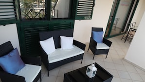 A balcony with wicker furniture, including a sofa and chairs, and a small table with a lantern. - Top floor apartment with amazing ocean views  (Costa Teguise)