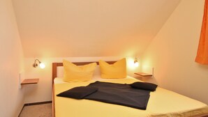 Una camera da letto con un letto, due comodini e due lampade a parete.