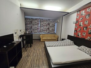 A bedroom with a bed, a sofa, a desk, and a radiator. - Central Class Bucharest (Bucharest)