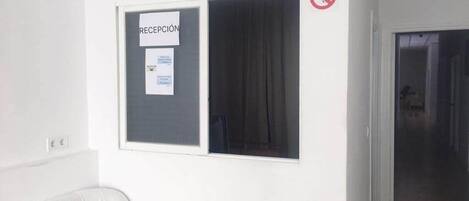 A reception area with a sign indicating 'Wifi Free' and a 'No Smoking' sign.