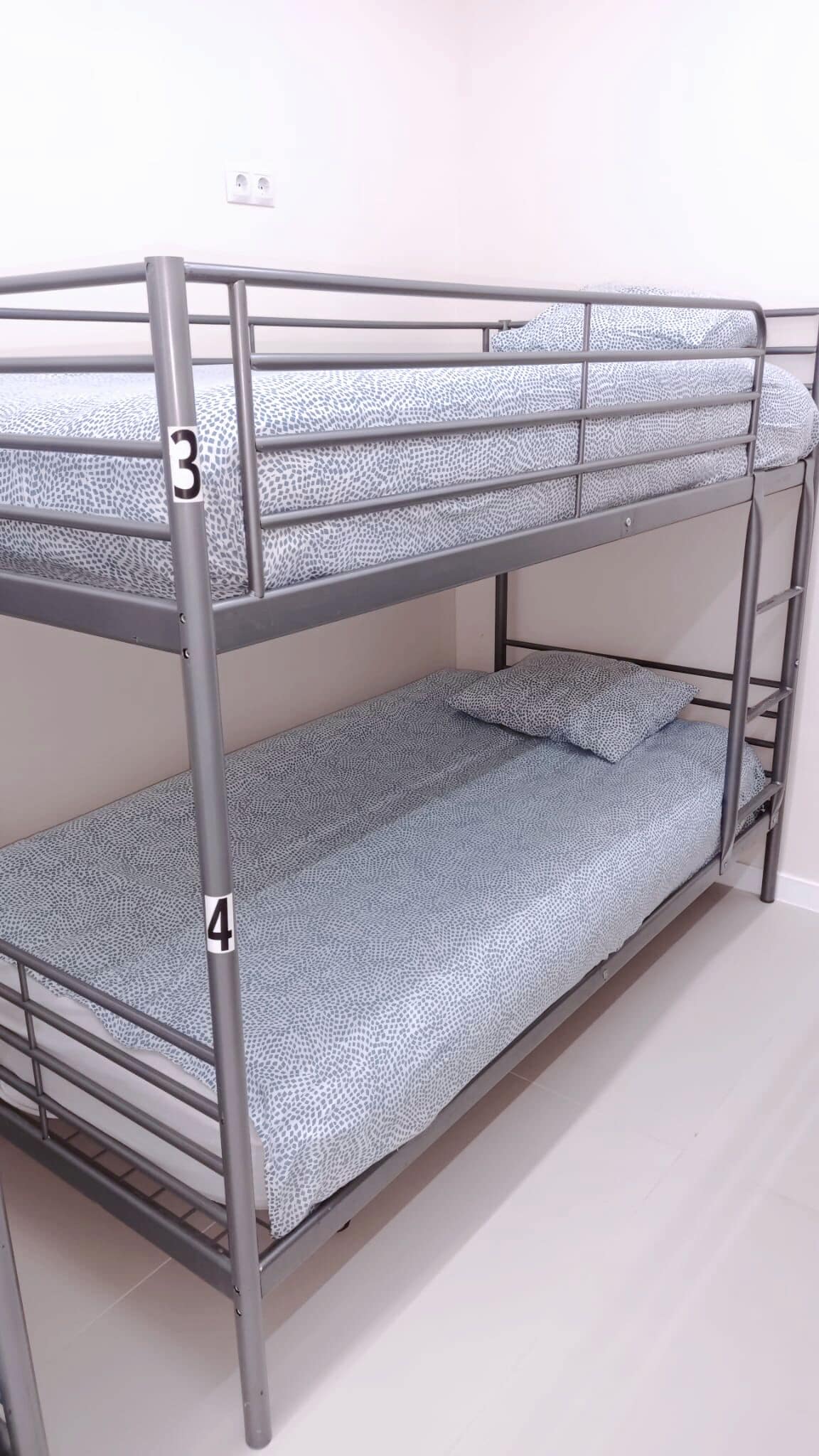 A bunk bed with two levels, each with a patterned mattress.