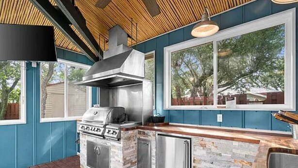 An outdoor kitchen with a grill, a built-in sink, and a stone backsplash. - Great Views -Pet Friendly -Great Rates for Late Summer and Fall Dates -Book Now! (Mexico Beach)