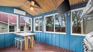 A covered outdoor area with a wooden deck, a table with stools, and a barbecue grill. - Great Views -Pet Friendly -Great Rates for Late Summer and Fall Dates -Book Now! (Mexico Beach)