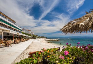 Un hotel frente al mar con terraza exterior y vistas al océano.