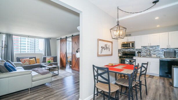 A modern apartment with a living room, dining area, and kitchen.