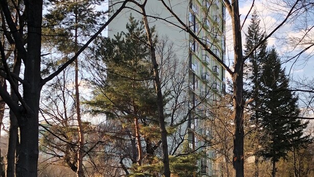 A park with trees and a building in the background. - Apartman Sever Hroncova (Kosice)