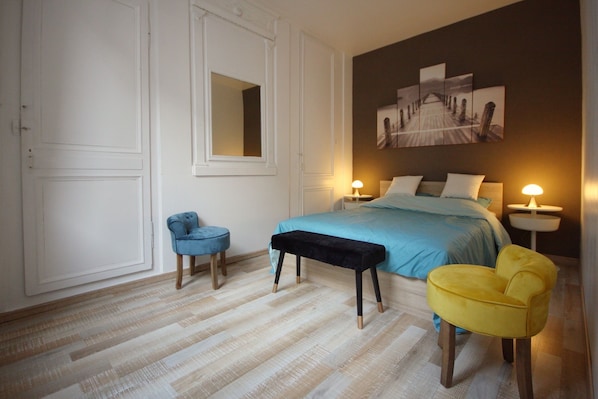 A bedroom with a bed, bedside tables, a chair, a bench, and a large painting on the wall. - "Le Cardinal" Fécamp Seaside in Normandy 76 (Fécamp)