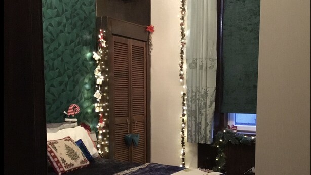 Ein Schlafzimmer mit Bett, Kleiderschrank, Schreibtisch und Fenster.