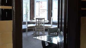 Ein Zimmer mit Glastisch, zwei Stühlen und Blick durch große Fenster.