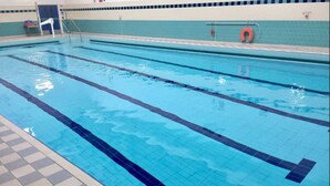 Ein Schwimmbecken mit deutlichen Bahnen und Fliesenboden.