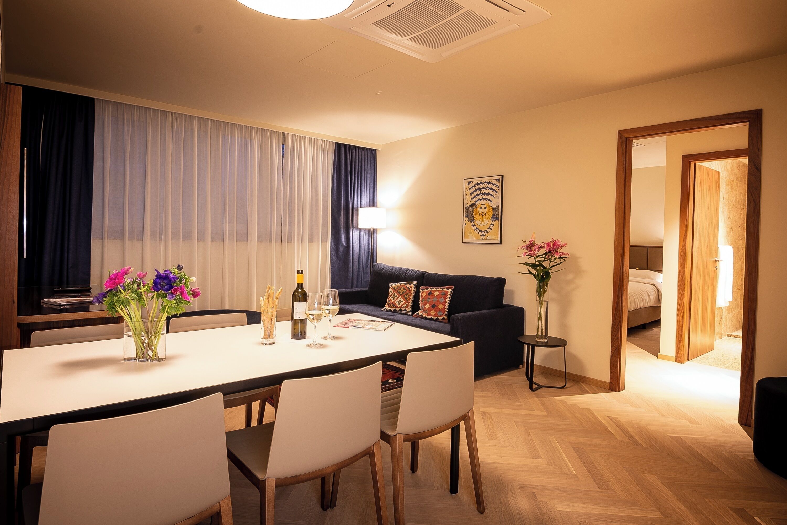 Ein modernes Hotelzimmer mit Essbereich, einer Couch und einem Bett.