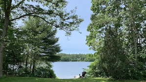Une vue sur le lac, avec une chaise et une jetée qui s’avance dans l’eau.