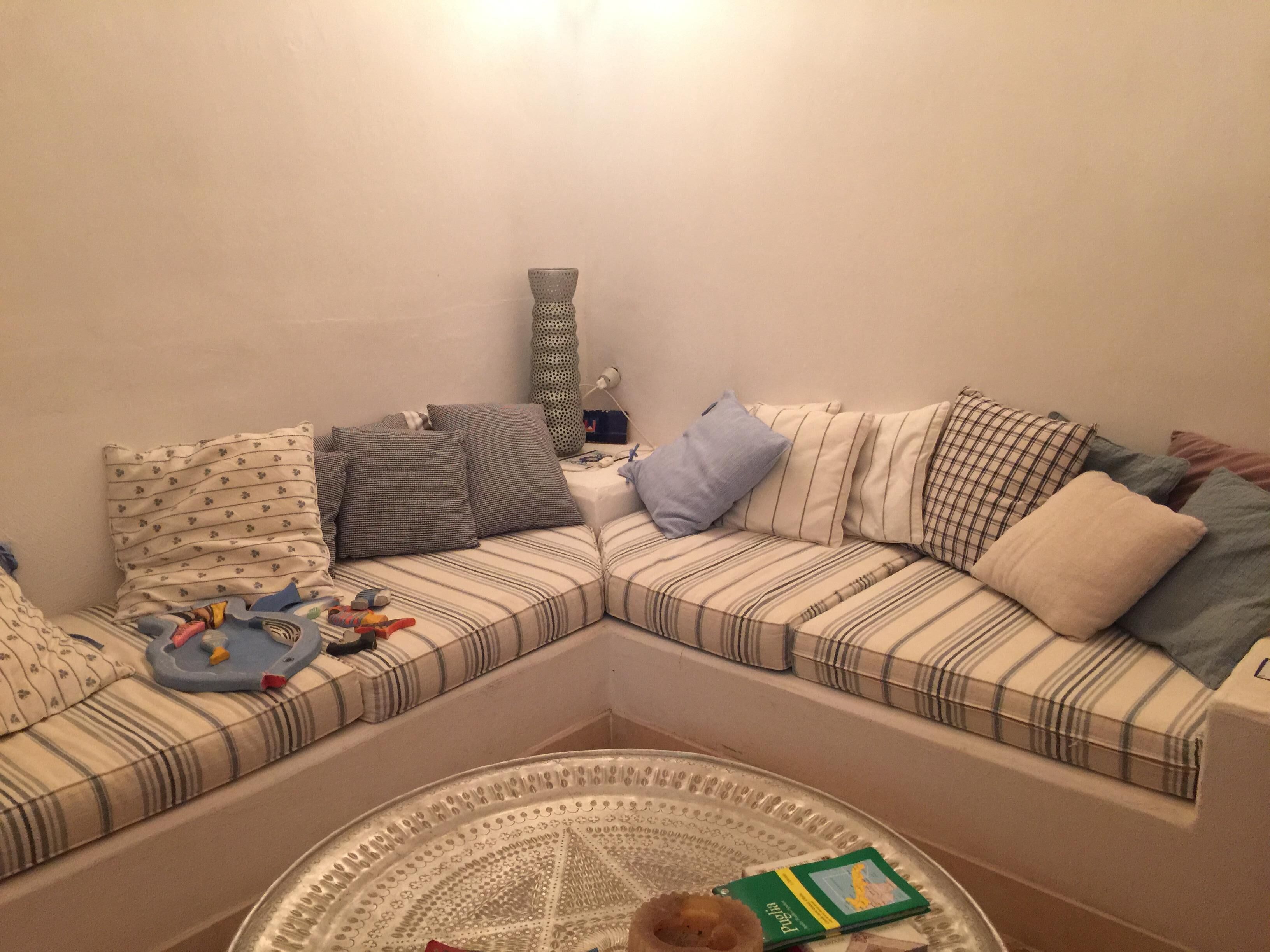 A cozy living room with a sectional sofa, a coffee table, and a lamp.