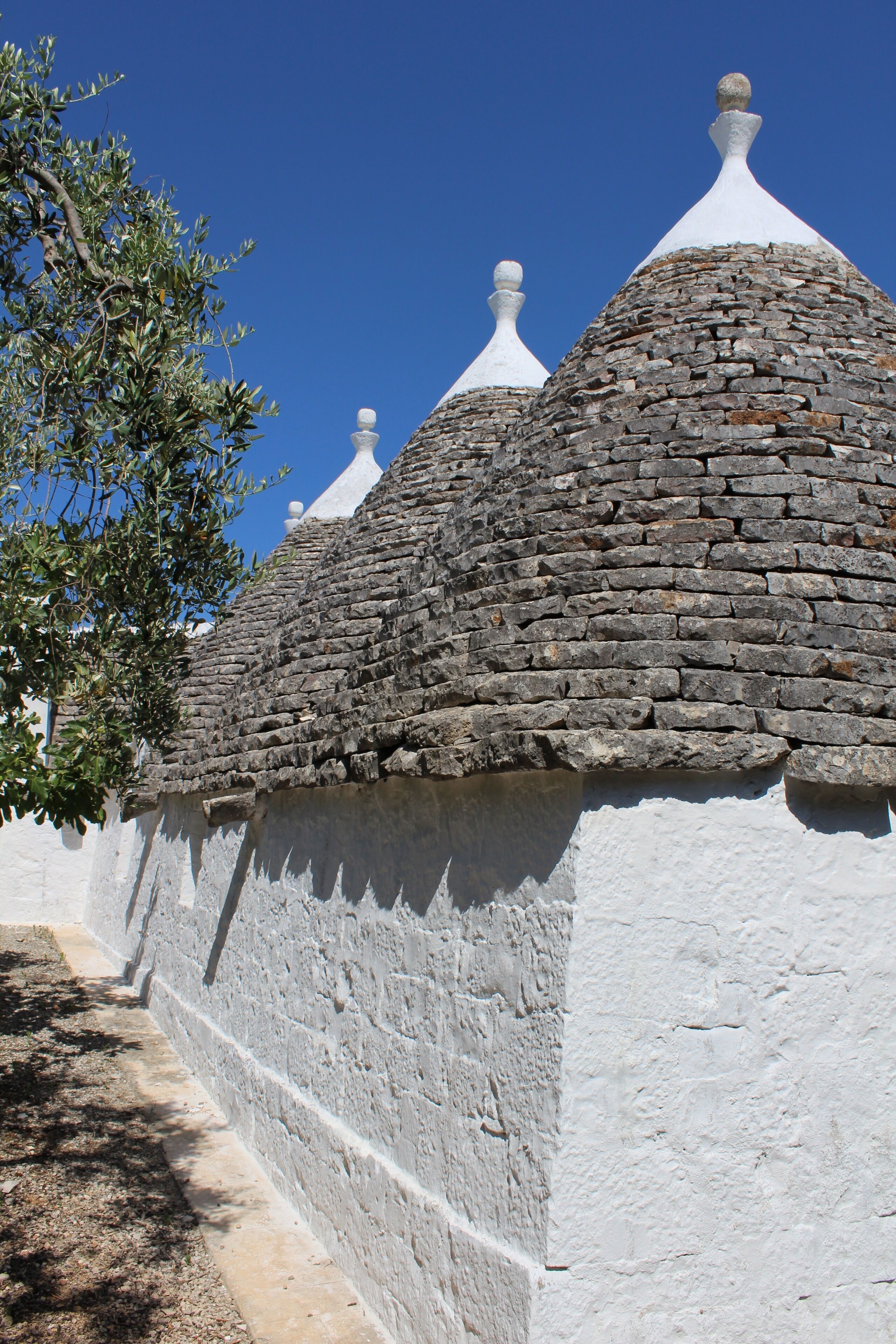 A traditional building with stone walls and conical roofs.