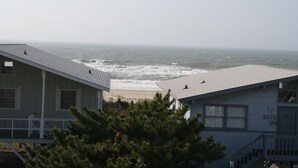 A coastal view with two buildings, one with a visible 'BUIE' sign, overlooking the beach and ocean. - I LOVE BEACH MUSIC (Ocean Isle Beach)