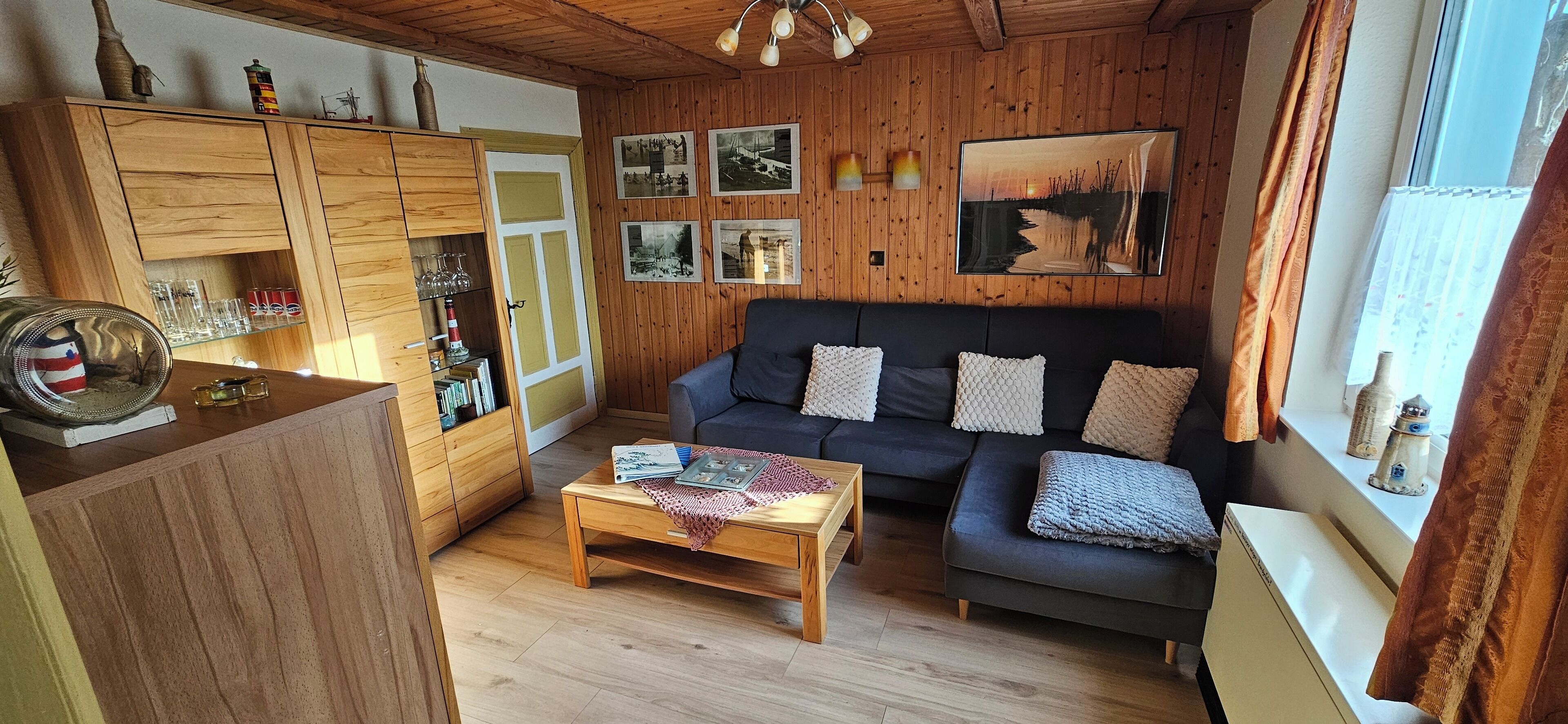 Un salon chaleureux avec un canapé foncé, des meubles en bois et une table basse.