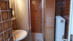 A bathroom with a sink, shower, and toilet.