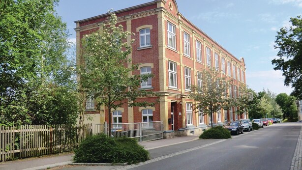 A multi-story red brick building with a symmetrical facade, large windows, and a central entrance. - Lovely home in Auerbach with sauna (Auerbach)