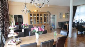 A dining area with a wooden table, black chairs, a chandelier, and a cabinet with glass doors. - Lovely home in Auerbach with sauna (Auerbach)