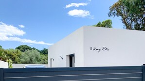 Un bâtiment moderne avec une façade blanche et un portail noir.