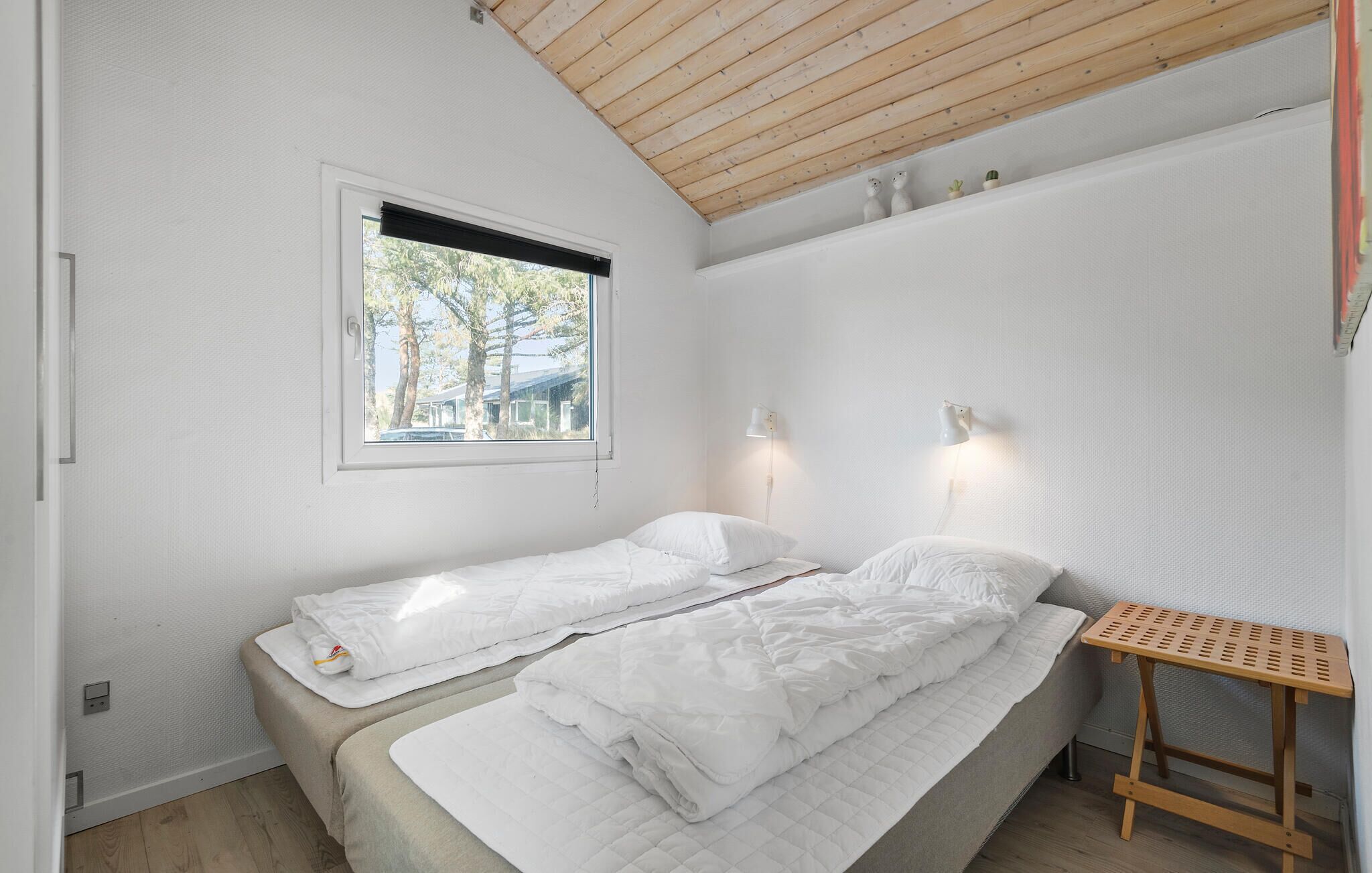A small, single-room accommodation with a bed, a window, and a small table.